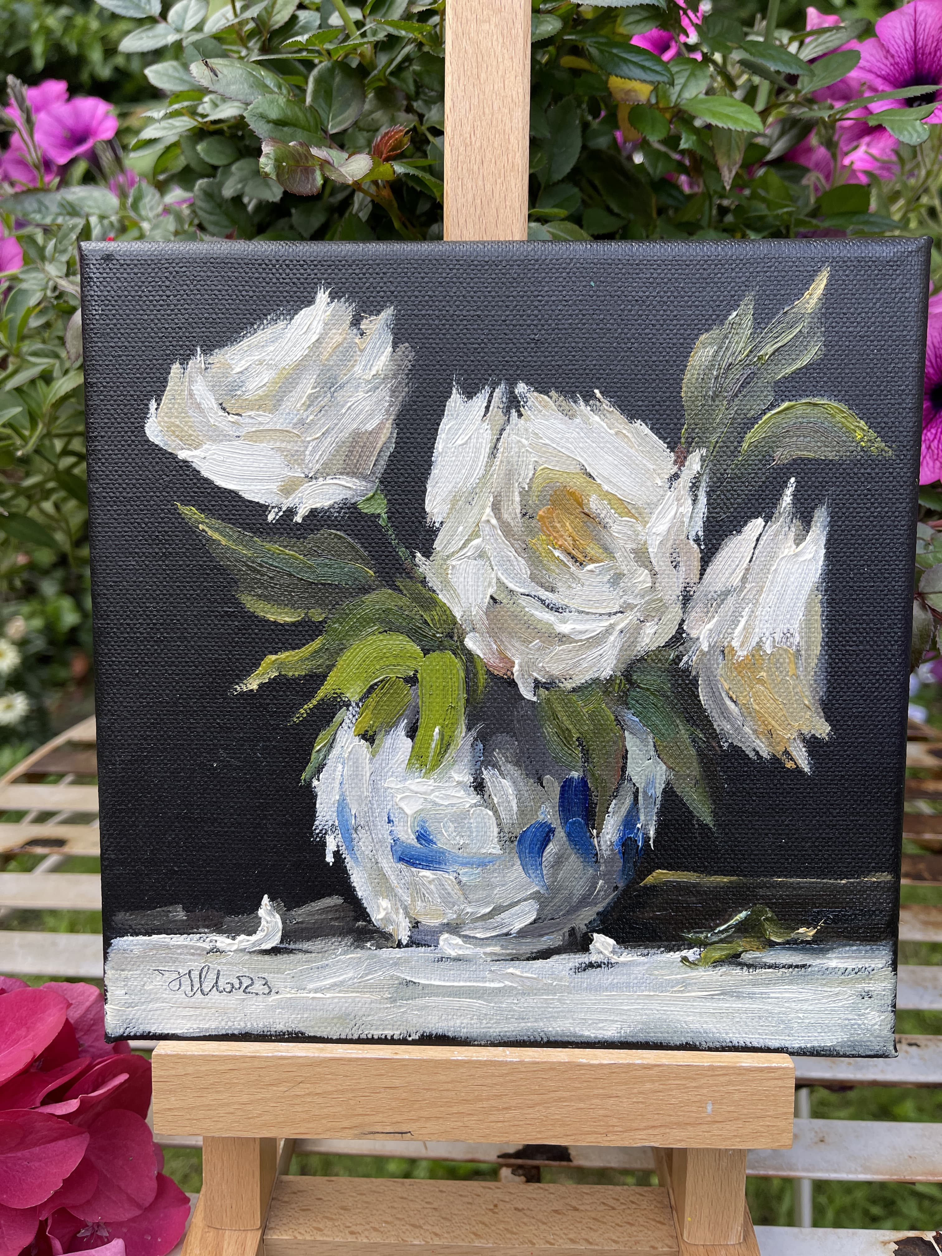 White roses in vase on black canvas