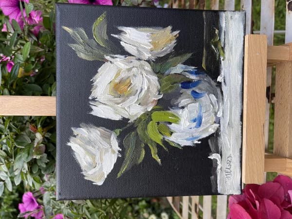 White roses in vase on black canvas